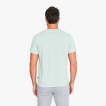 Back view of a man wearing a light green t-shirt on a white background
