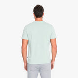 Back view of a man wearing a light green t-shirt on a white background