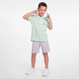 Full body picture of a kid wearing a mint green polo shirt with light gray shorts
