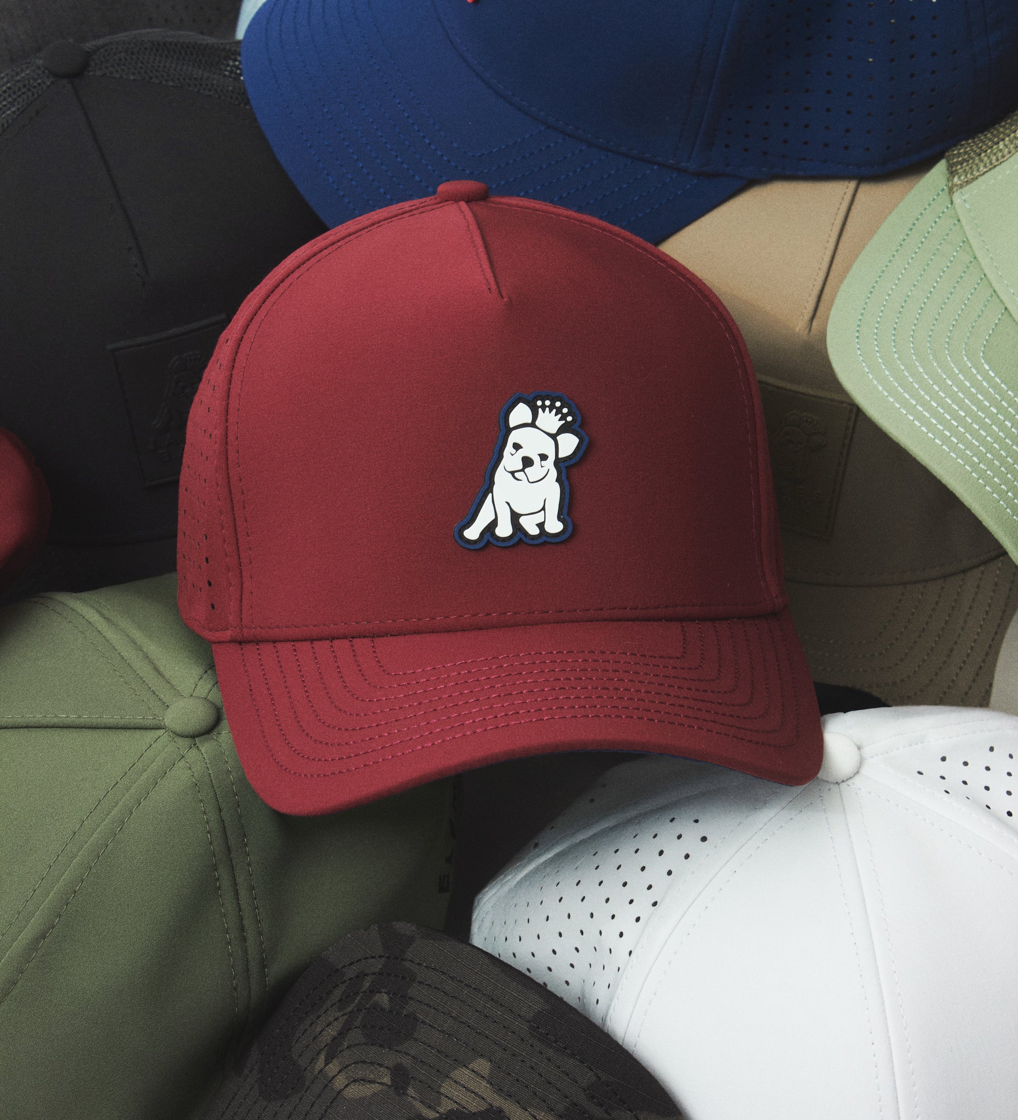 Red cap with a white logo on top of other colored caps.