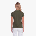 Back view of a woman wearing a green polo with an embroidered dog logo on a white background