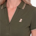 Close-up of a green polo with an embroidered beige dog logo