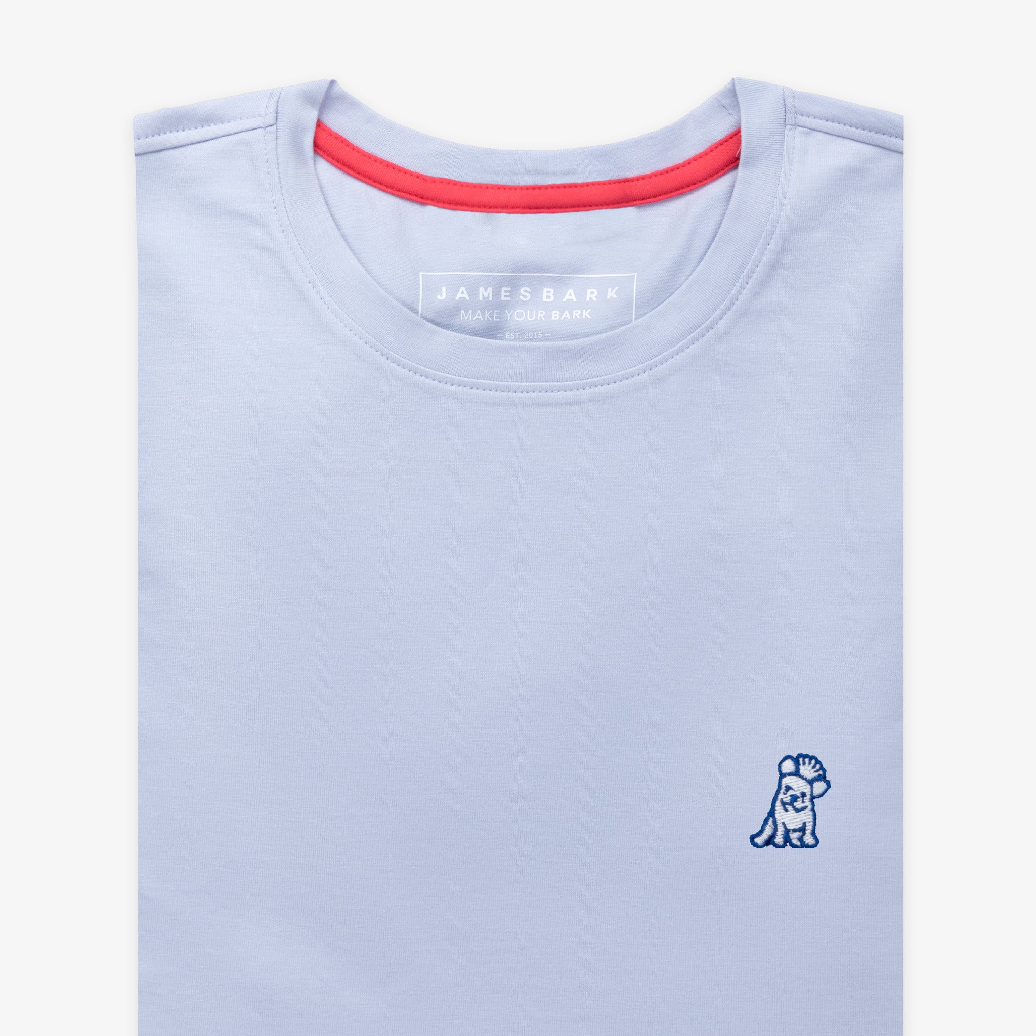 Flat-lay view of the light blue t-shirt showing the neckline with a red inner collar detail and a small embroidered logo on the chest.