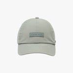 Light grey baseball cap by James Bark, with a rectangular rubberized logo patch