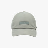 Light grey baseball cap by James Bark, with a rectangular rubberized logo patch