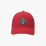 Front view of a red James Bark baseball cap featuring a circular black and white rubberized patch