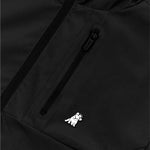 Close-up of a black jacket featuring a black, waterproof zipper on a chest pocket. Below the zipper, there is a small embroidered white dog wearing a crown, adding a playful and distinctive detail to the design.