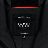 Close-up of the inside label of a black jacket. The black label features the text 'PRIVÉ SOCIETY' at the top, with 'JAMES BARK' prominently in the center, followed by 'EST. 2015.' Below, the label reads 'REGULAR FIT,' and a smaller tag beneath indicates the size 'M' and 'Made in China.' The design is minimal and clean, with a red accent visible in the lining.