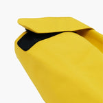 Close-up image of the hood attachment of a yellow James Bark jacket. The hood features a small Velcro strap for adjustment, and the inner lining appears to be black mesh for added ventilation.