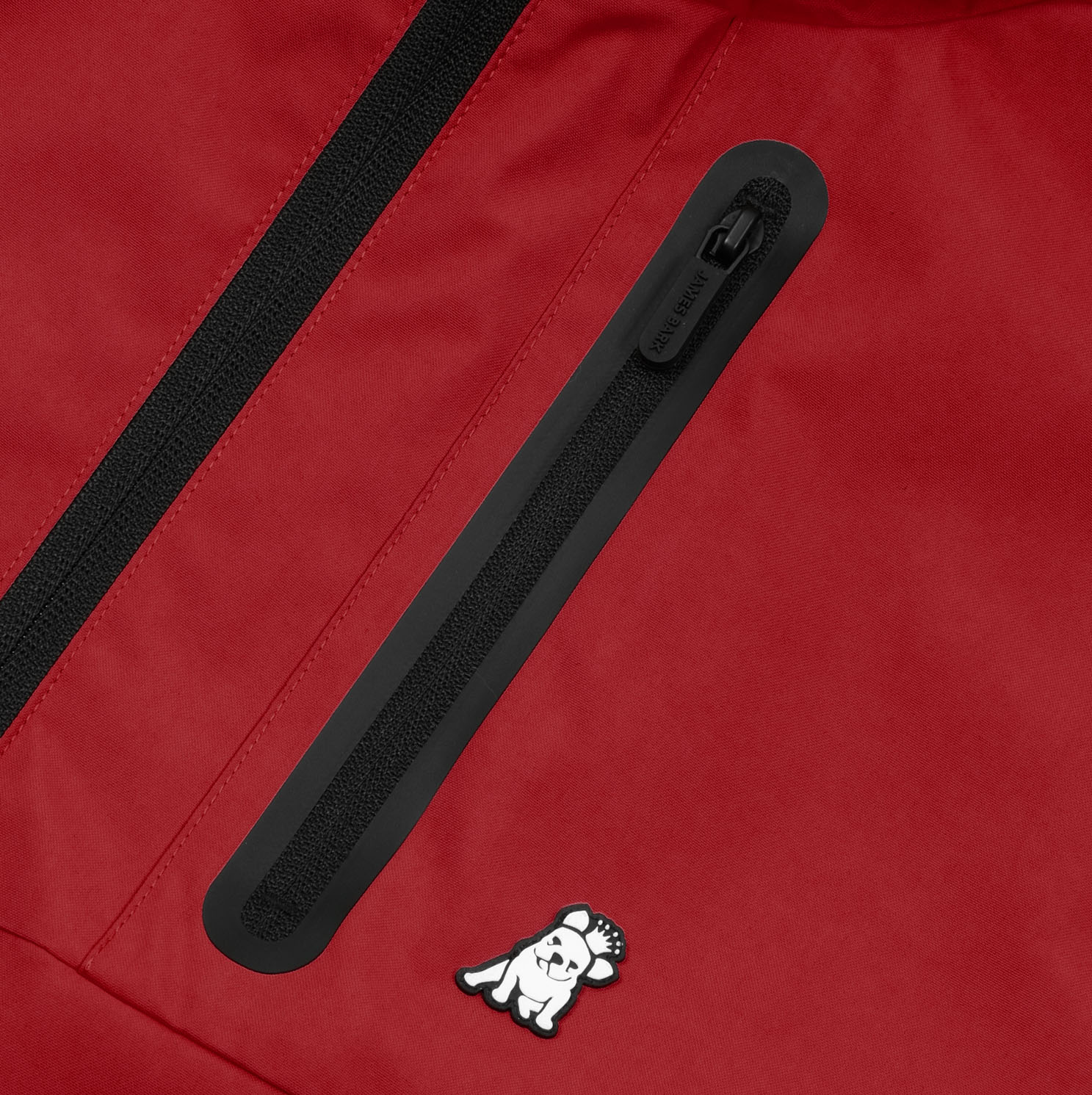 Close-up of the chest pocket with zipper and logo on the red jacket.