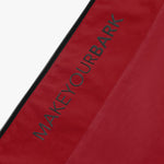 Close-up of the side pocket with zipper on the red jacket and the James Bark logo.