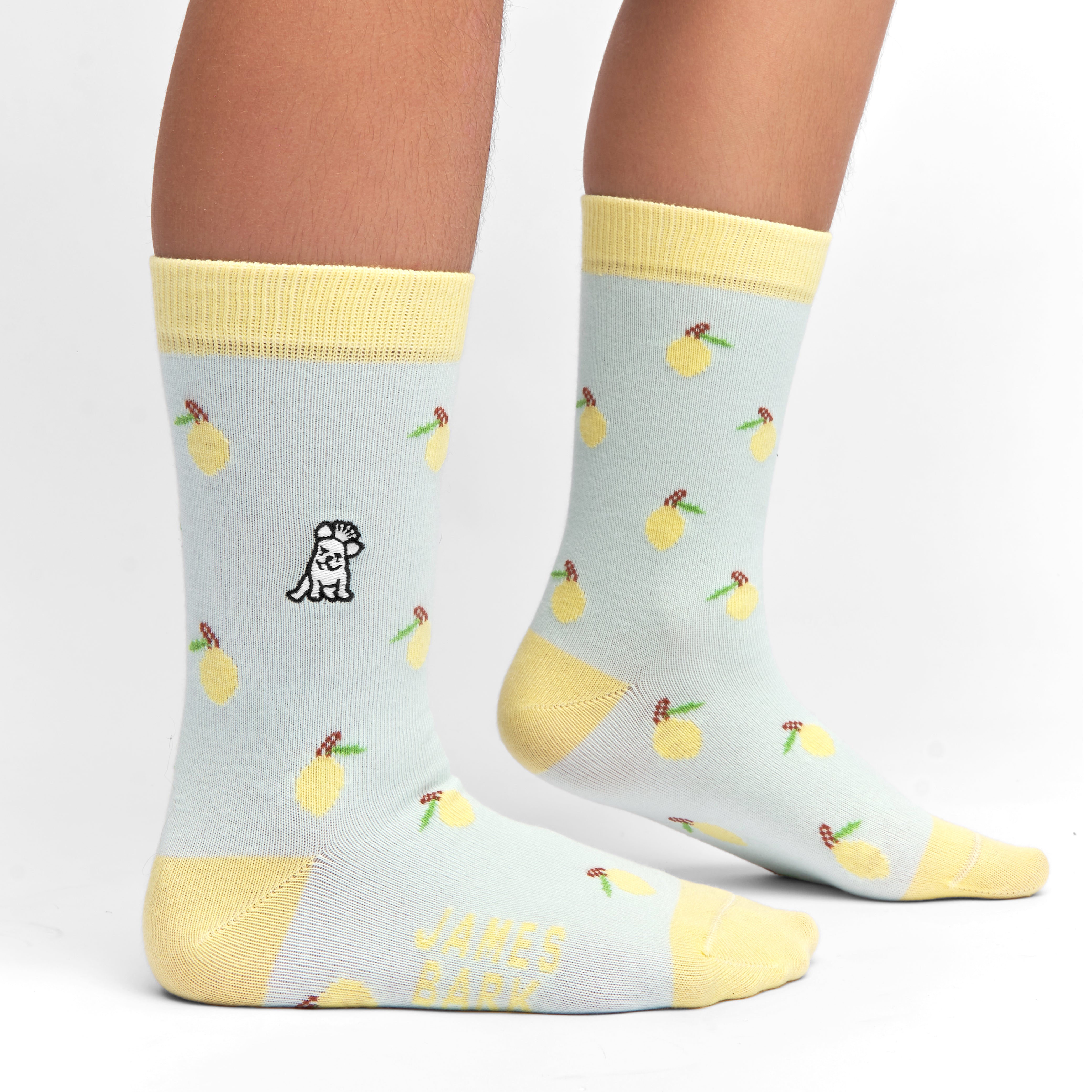 Light blue socks with yellow accents and a playful fruit pattern, shown worn to showcase the design and fit on the legs.