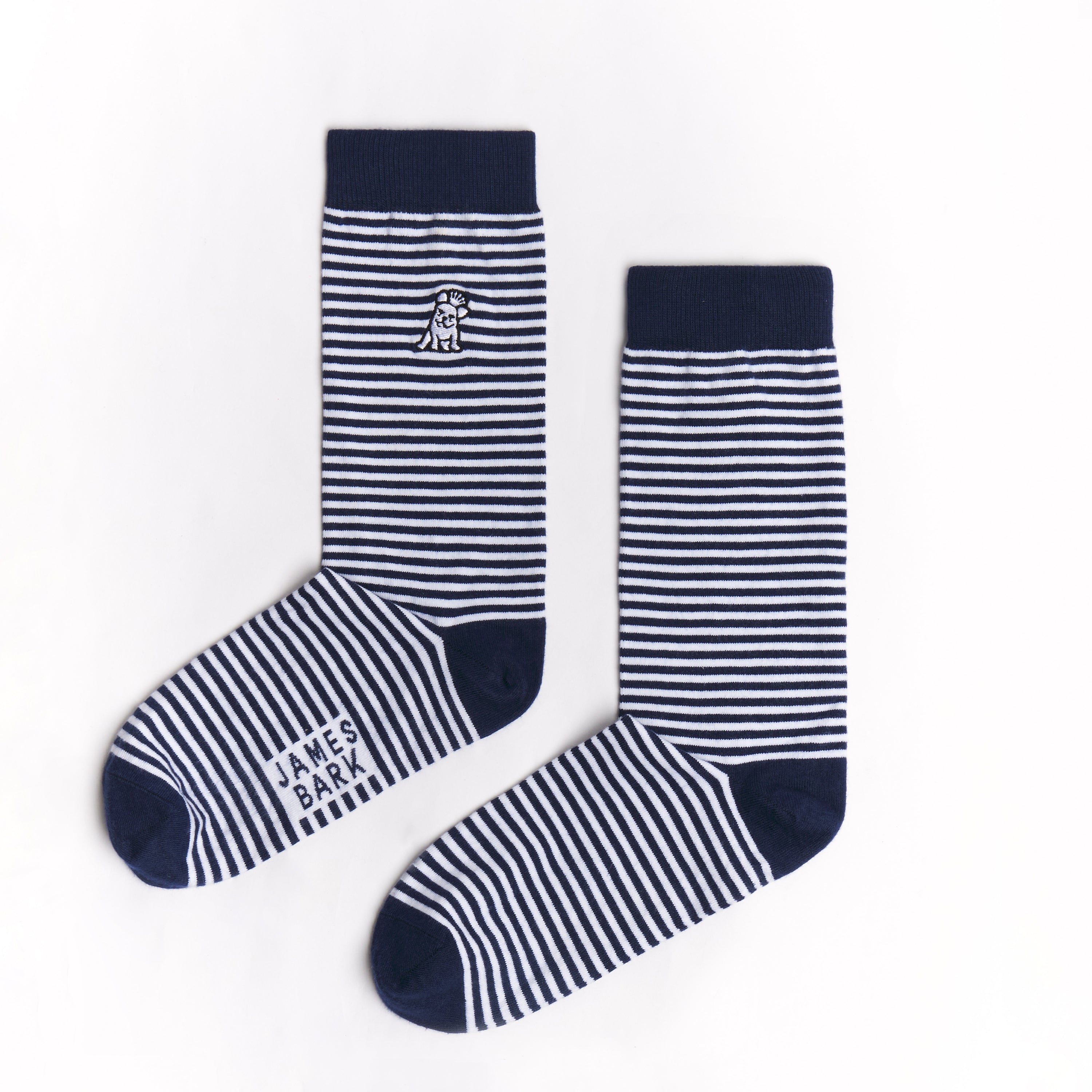 A pair of navy blue and white striped mid-calf socks with a solid navy cuff, heel, and toe. There is a small dog graphic near the ankle, and the text 'JAMES BARK' is printed near the toe. The socks are laid flat on a white surface.