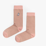 A pair of light pink mid-calf socks with subtle stripes, featuring a solid pink cuff, heel, and toe. There is a small dog graphic near the ankle. The socks are laid flat on a white surface.