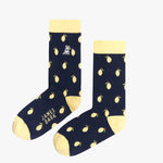 A pair of navy blue mid-calf socks with a yellow cuff, heel, and toe, featuring a pattern of lemons and the text 'JAMES BARK' printed in yellow near the toe. The socks are laid flat on a white surface.