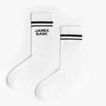 A pair of white mid-calf socks with two black stripes at the top and the text 'JAMES BARK' printed in black near the ankle. The socks are laid flat on a white surface.