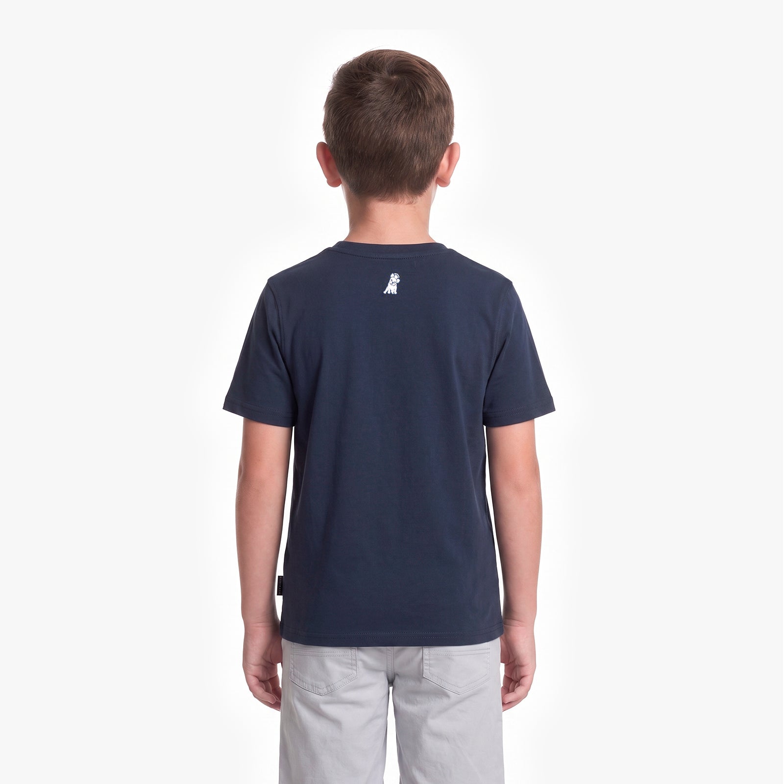 A child viewed from the back wearing a navy blue T-shirt with a small white dog logo on the upper back