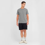 Man wearing a gray t-shirt and black shorts on a white background