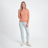 Woman wearing a brown sweater and light blue jeans on a white background