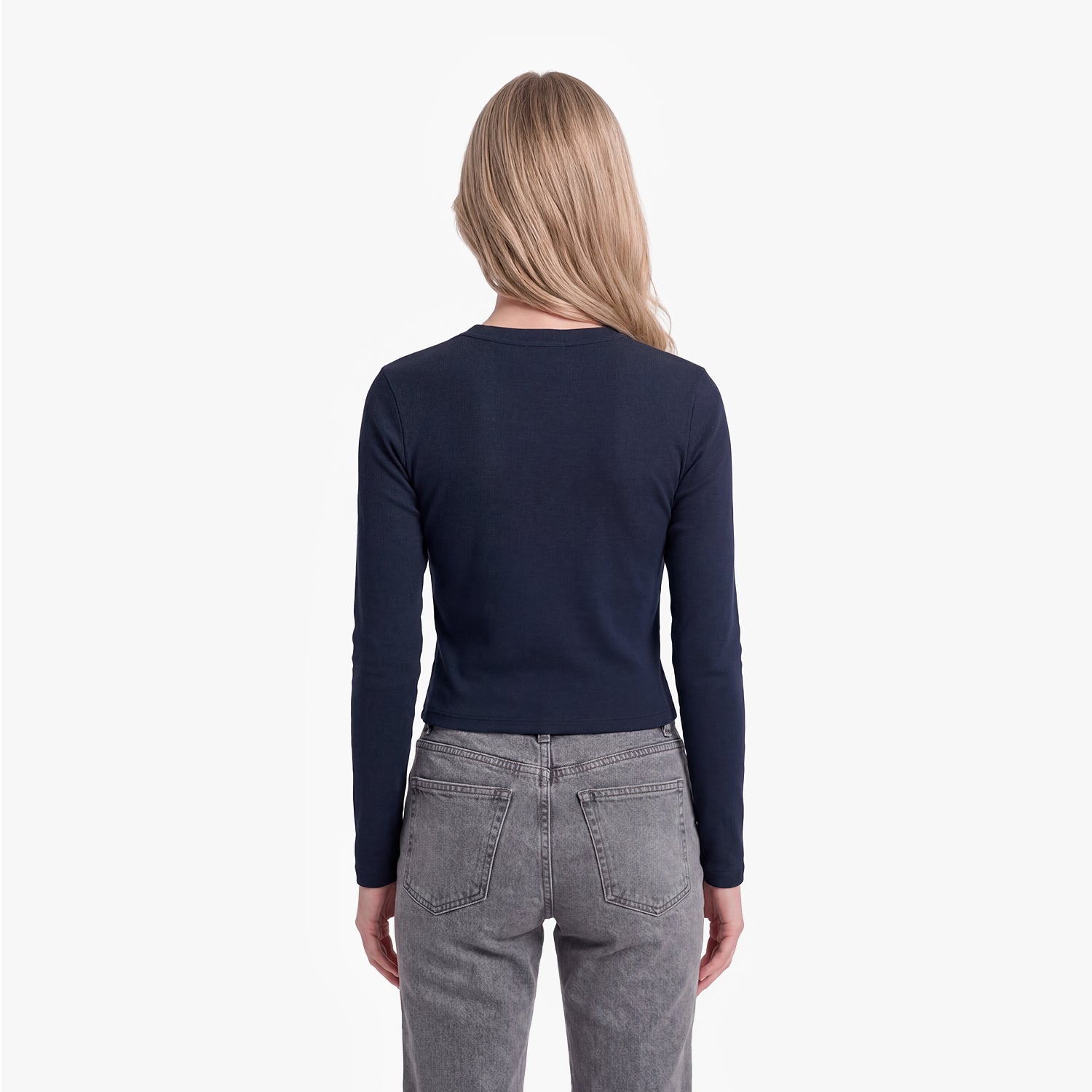 Person wearing a navy long-sleeve shirt and gray jeans on a white background