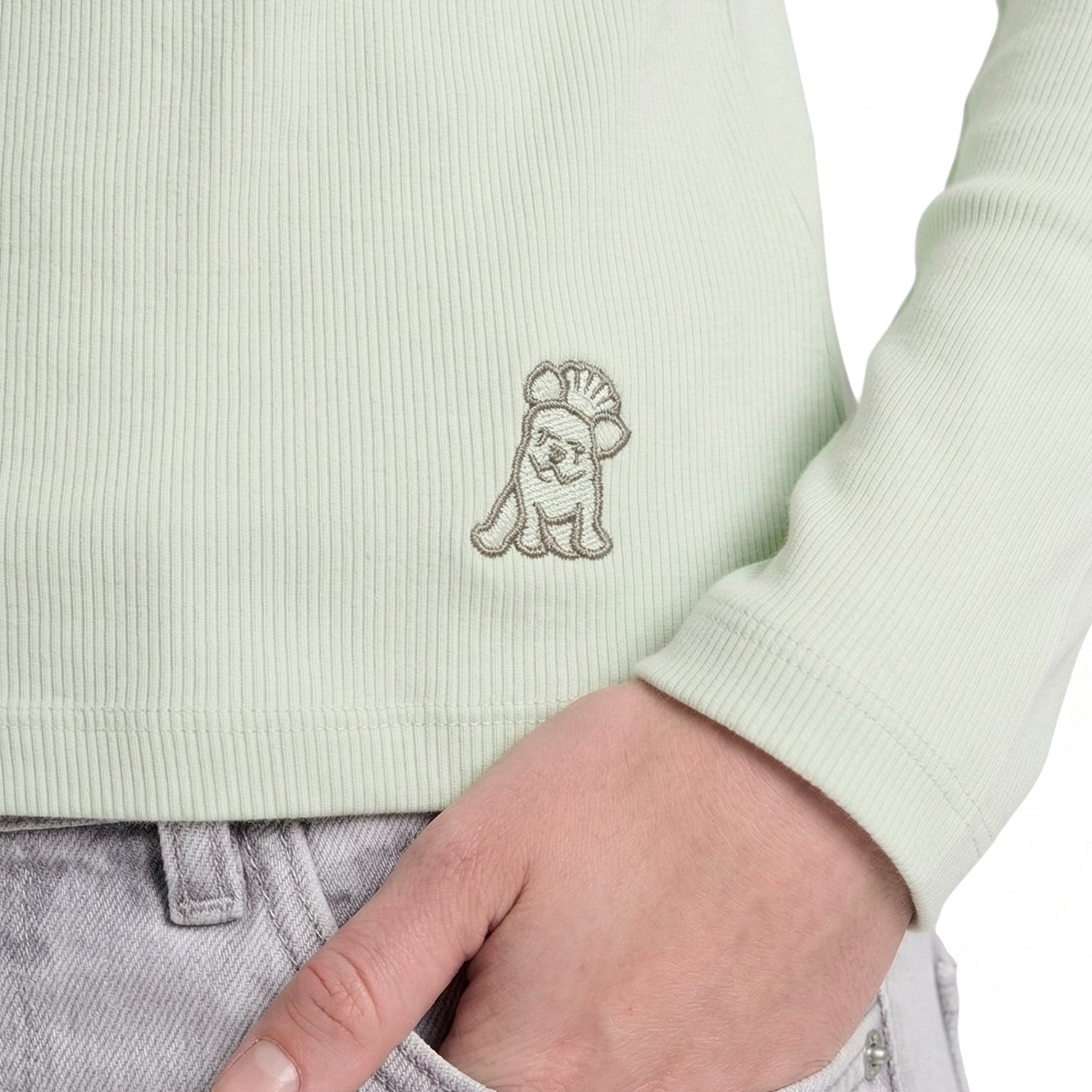 Light green ribbed sweater with a small embroidered design on a white background