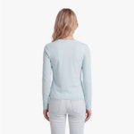 Woman wearing a light blue sweater and white pants on a white background