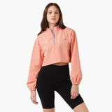 A model wearing a cropped jacket in a pink color, styled with sporty shorts. The jacket has a relaxed fit , showcasing a casual look. The model stands in a confident pose against a neutral background.