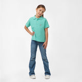 Full-body shot of the girl wearing the mint green polo shirt and blue jeans, standing with one hand on her hip and smiling.