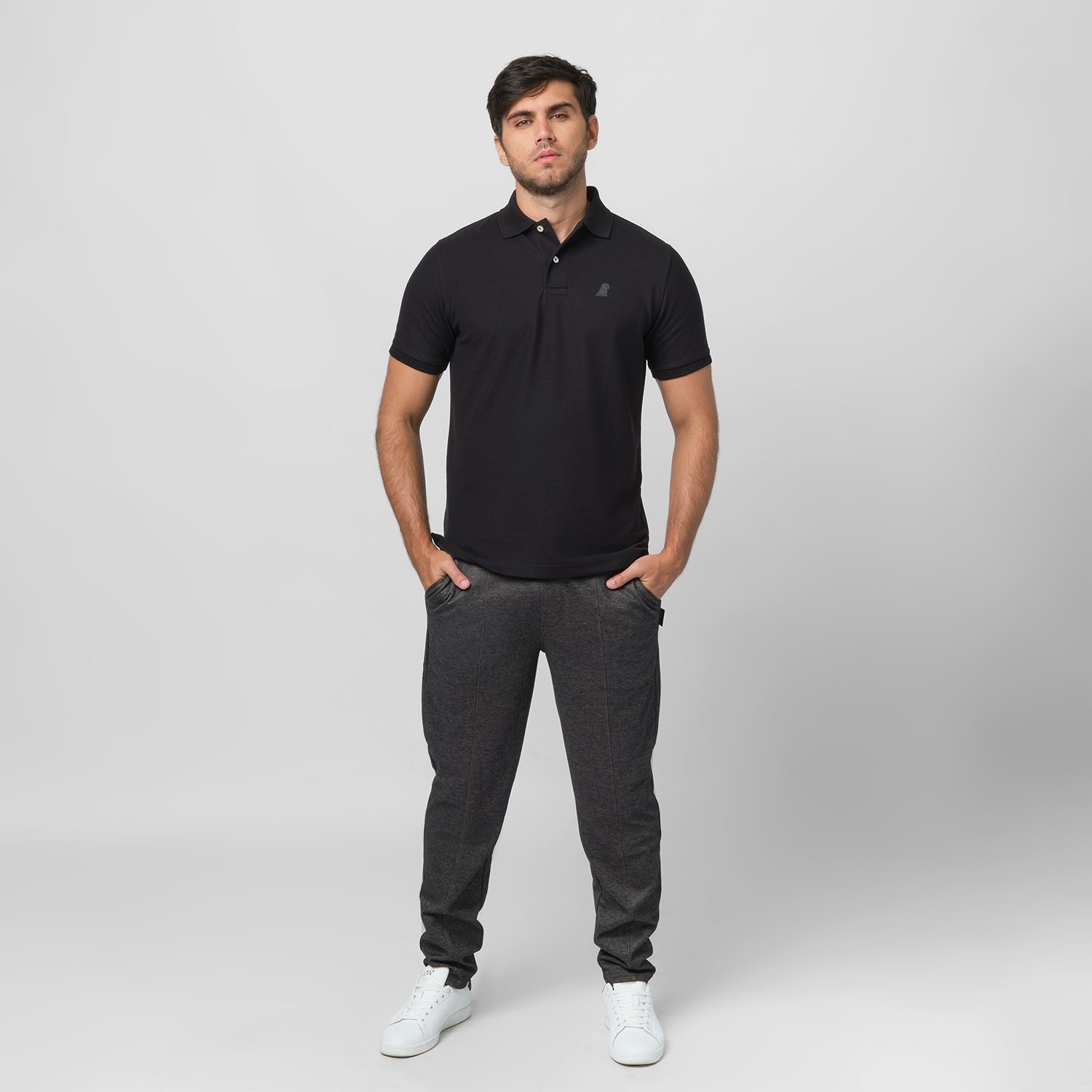 Full-body shot of the model wearing the polo, standing casually, hands in his pockets.