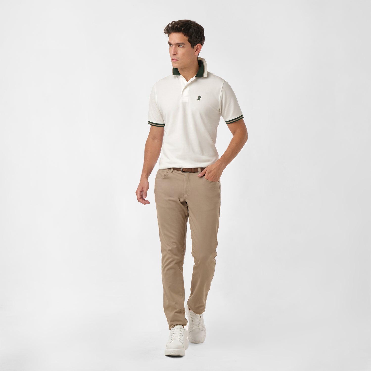 Full-body view of a man wearing the white polo shirt and beige pants: The man is standing in a casual pose, showing the overall fit of the shirt paired with beige pants.