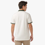 Back view of a man wearing the white polo shirt: The man is standing with his back to the camera, showing the back fit and design of the shirt, with dark green accents on the collar and cuffs.