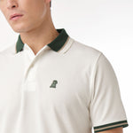 Side view close-up of the collar and chest of the white polo shirt: A detailed side profile showing the dark green collar and sleeve cuff, along with the small embroidered dog logo on the left chest.