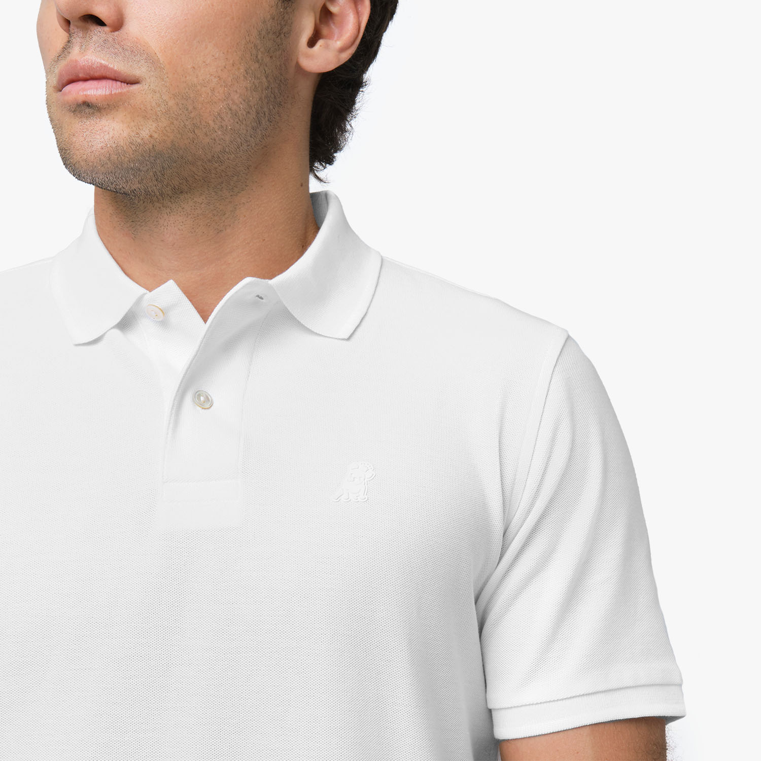 Close-up of the collar and embroidered logo of the white polo shirt, highlighting the branding detail.