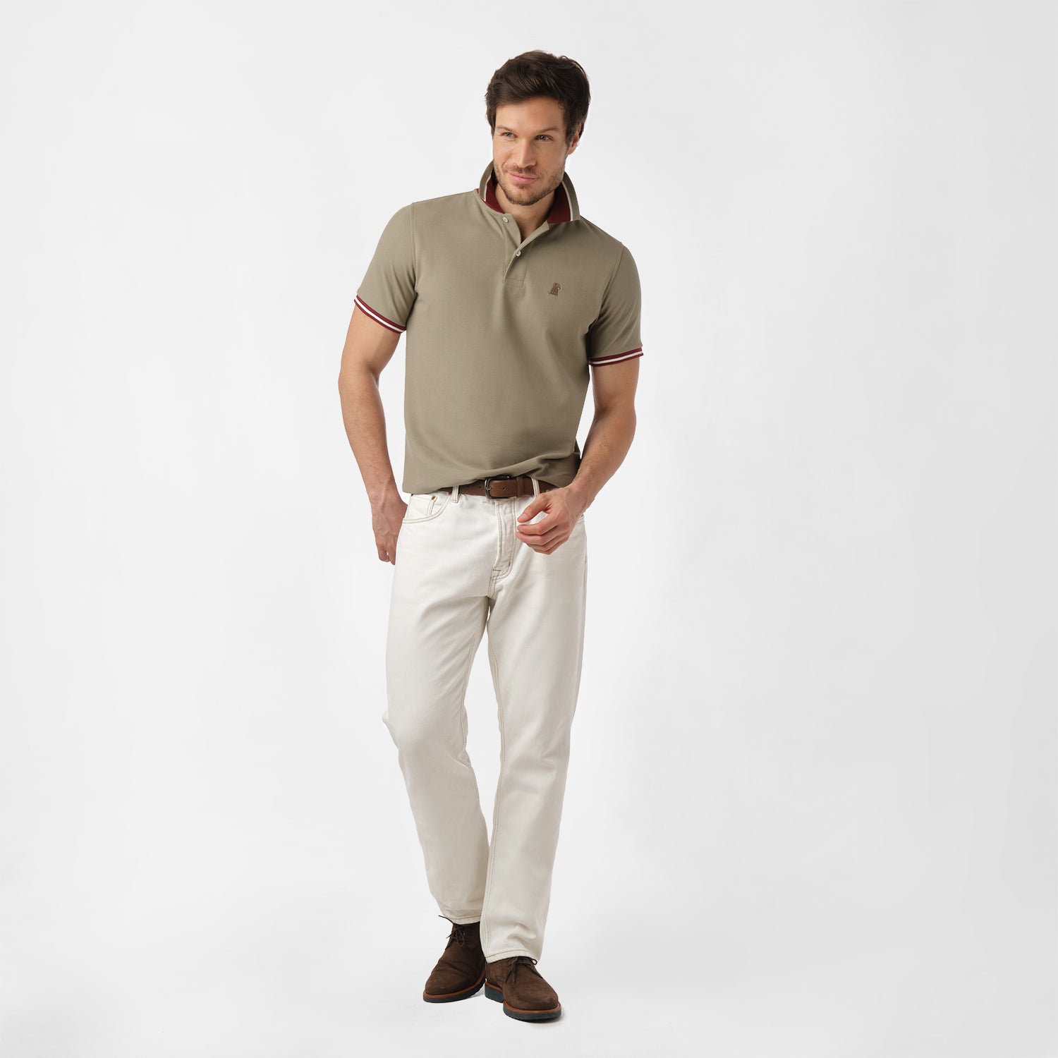 Full-body view of a man wearing the olive polo shirt and white pants: The man is standing in a relaxed pose, showing the overall fit of the shirt paired with white pants.