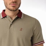 Side view close-up of the collar and chest of the olive polo shirt: A detailed side profile showing the maroon collar with white piping and the small embroidered dog logo on the left chest.