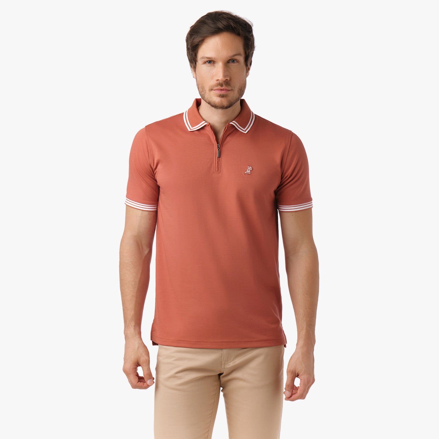 Male model wearing a rust-colored polo shirt with white trim, standing with hands relaxed.