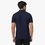 Rear view of a man wearing the navy blue polo shirt, showing the fit from behind.