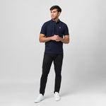 A navy blue polo shirt laid flat, showing the collar and small embroidered logo on the chest.