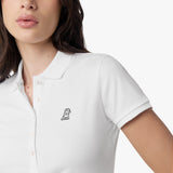 Close-up of the woman’s face and chest, highlighting the collar and black logo on the white polo shirt.