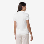 Rear view of the woman wearing the white polo shirt, showing the back design.