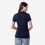 Rear view of the woman wearing the navy blue polo shirt, showing the back design.