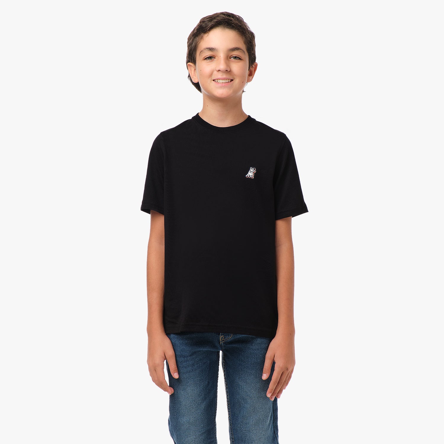 Front view of a boy standing and wearing a black t-shirt with a small logo on the chest.