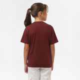 Rear view of a girl wearing the maroon t-shirt, standing with her hands behind her back.