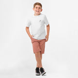 Full-body shot of the boy wearing the white T-shirt with the graphic on the back, paired with pink shorts and standing.