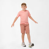 Full-body view of a boy wearing the light pink t-shirt and matching shorts, standing with his arms slightly outstretched.