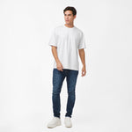 Full-body shot of the model wearing the white t-shirt, standing in a relaxed pose with hands at his sides.
