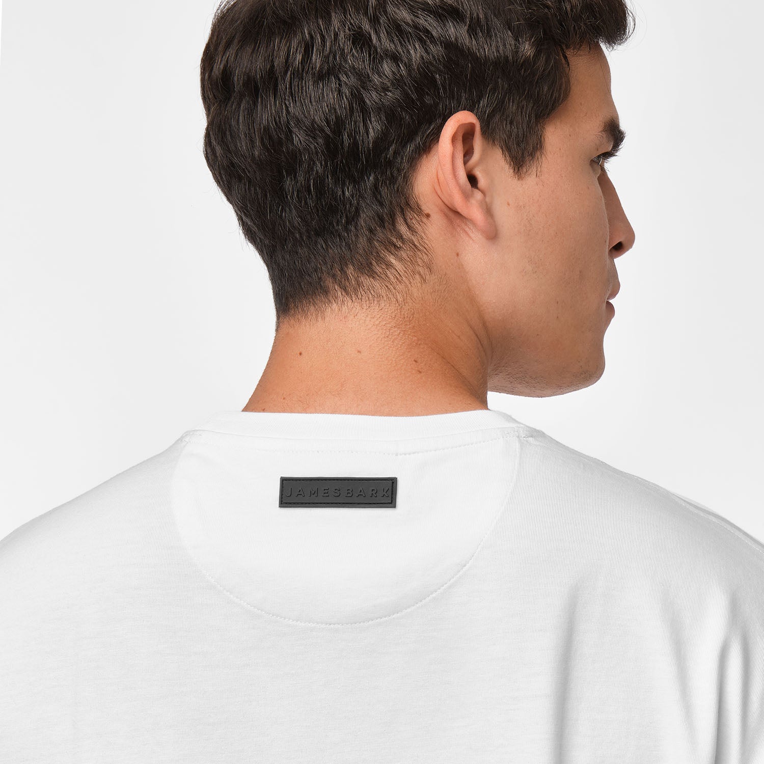 Close-up of the back of the t-shirt focusing on the black rectangular tag.