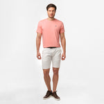 A full-body image of the man wearing the light pink t-shirt and white shorts, standing in a relaxed posture.