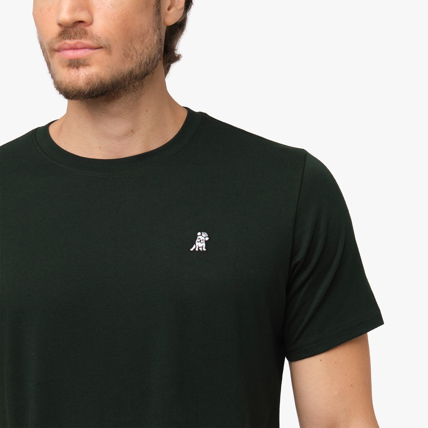 Close-up of the upper chest area of the black t-shirt, focusing on the small embroidered animal logo near the neckline.