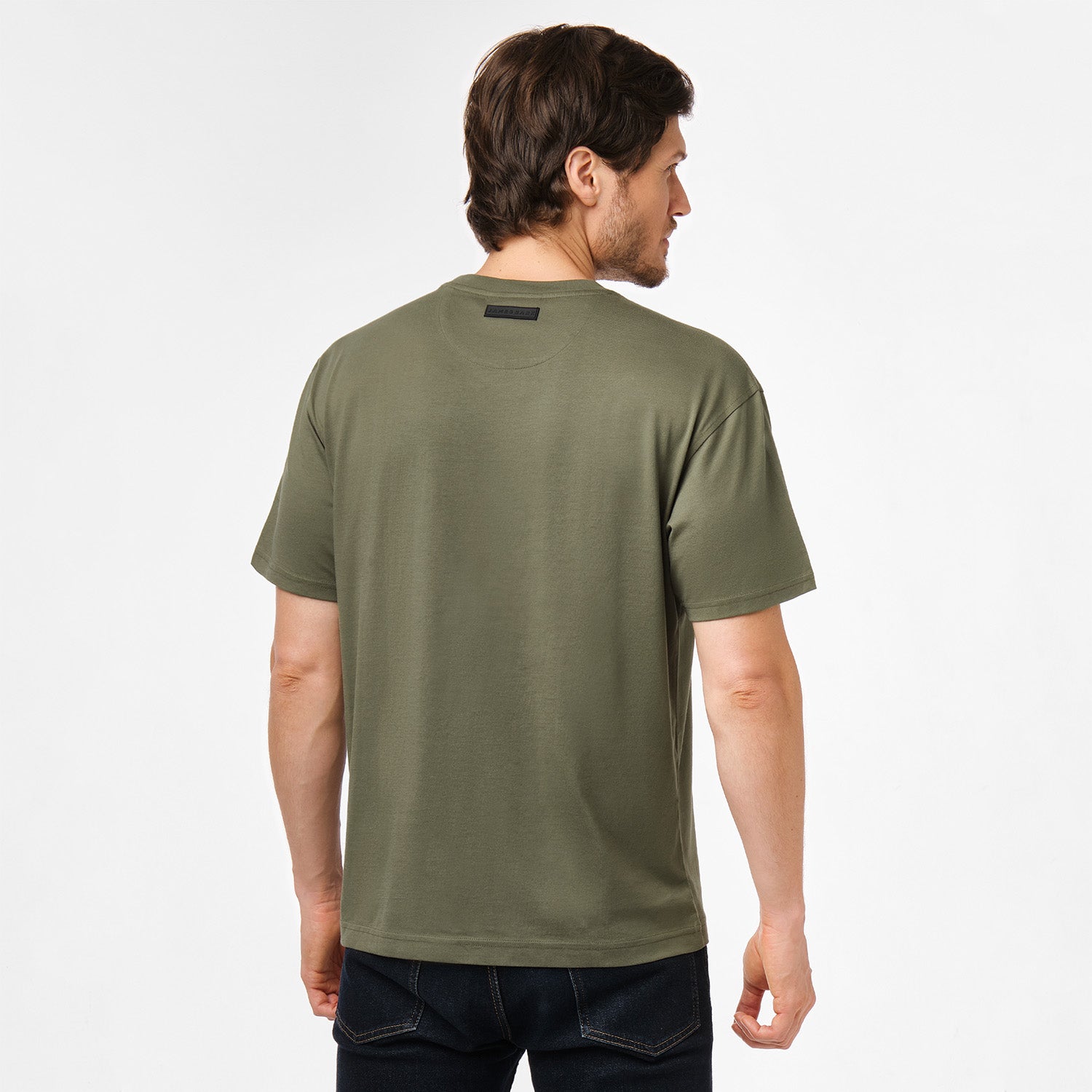 Rear view of the model wearing the olive green t-shirt, showcasing the fit from behind.
